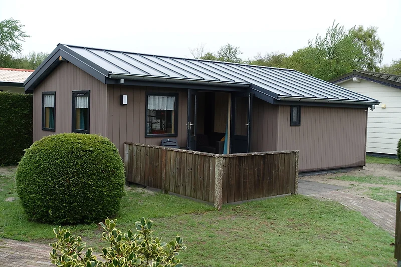 Freistehendes Haus mit Nebengebäude, grünem Garten und Zufahrt.