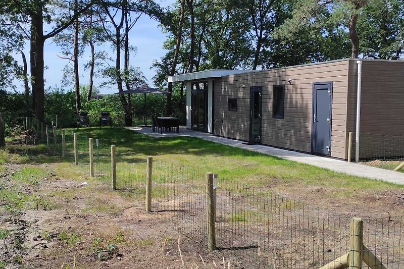 Gemütliches Ferienhaus mit großem Garten und gepflegtem Rasen.