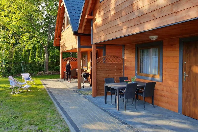 Gemütliches Blockhaus mit Garten, Gehweg und schattigem Hof.