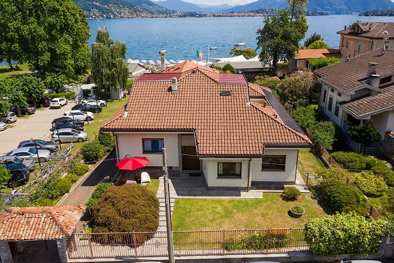 Villa mit Balkon, Bergblick und kleinem Auto im Wohngebiet.