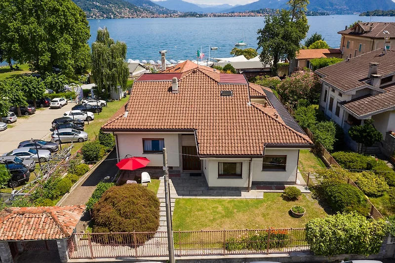 Villa mit Balkon, Bergblick und kleinem Auto im Wohngebiet.