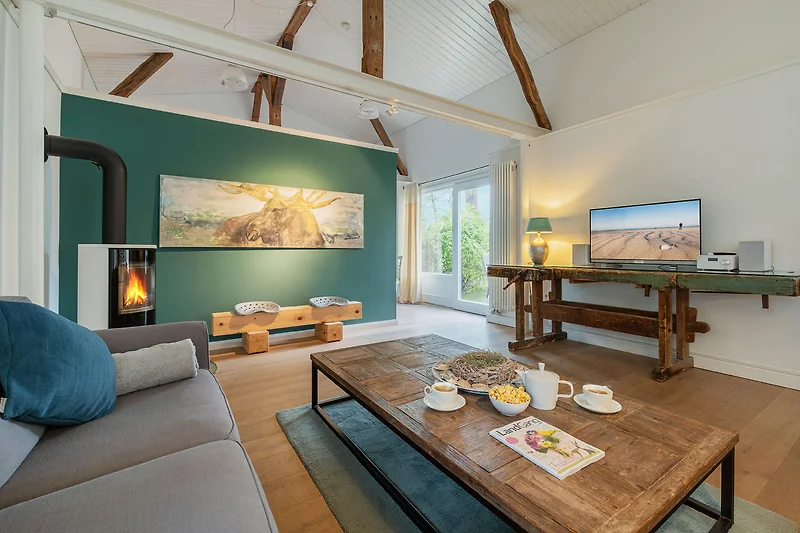 Wohnzimmer mit Holzdecke, Couch und stilvoller Beleuchtung.
