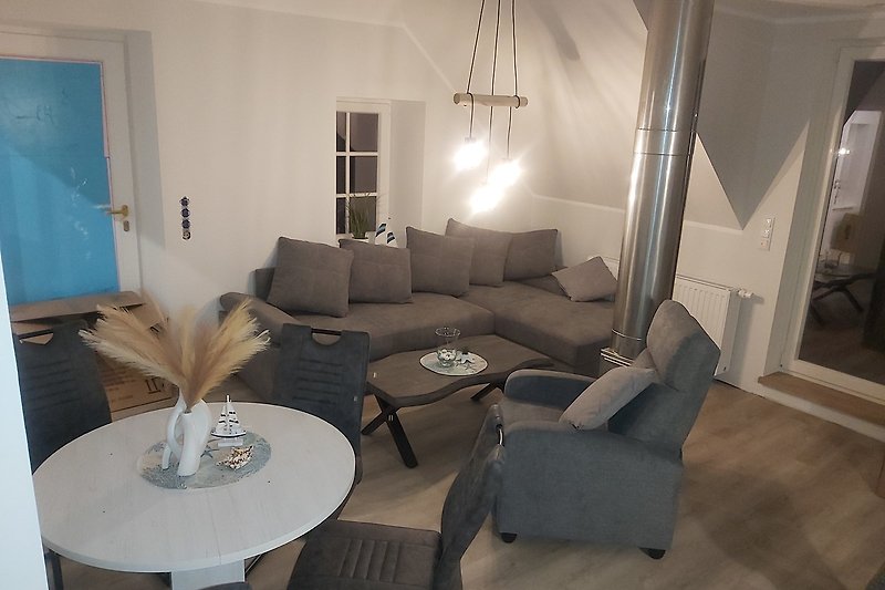 Gemütlicher Wohnbereich mit grauem Sofa und Holztisch.