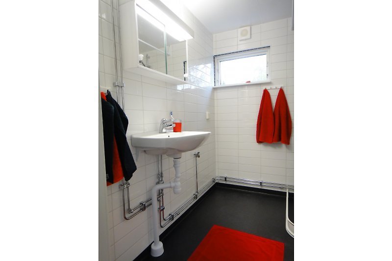 Modernes Badezimmer mit Wachmaschine, Dusche und richtiger Toilette