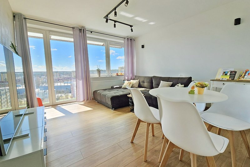 Wohnzimmer mit Holzdekor, Couch und Flachbildfernseher.