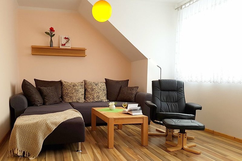 Helles und gemütliches Wohnzimmer mit Sofa/TV-Bereich, Kamin und Essplatz