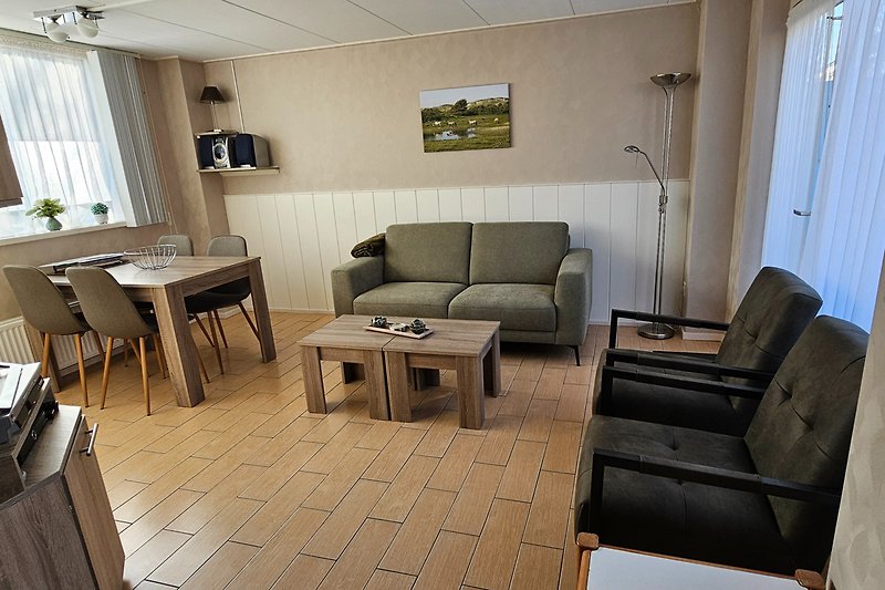 Wohnzimmer mit Holzmöbeln, Sofa, Stuhl und Kaffeetisch. Gemütliche Einrichtung.
