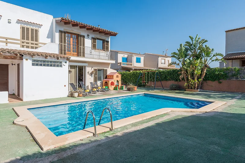 Villa mit Pool, Palmen und Sonnenliegen im Resort-Stil.