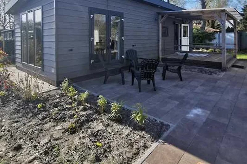Schöne Unterkunft mit Veranda und umliegendem (gerade neu angelegtem) Garten, mit Sonne und Schatten.
