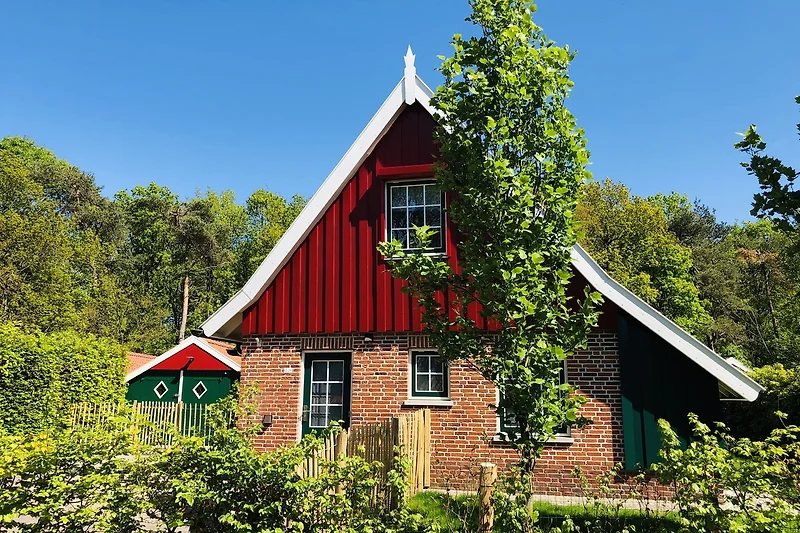 Ländliches Haus mit Garten, Scheune und Einfahrt.