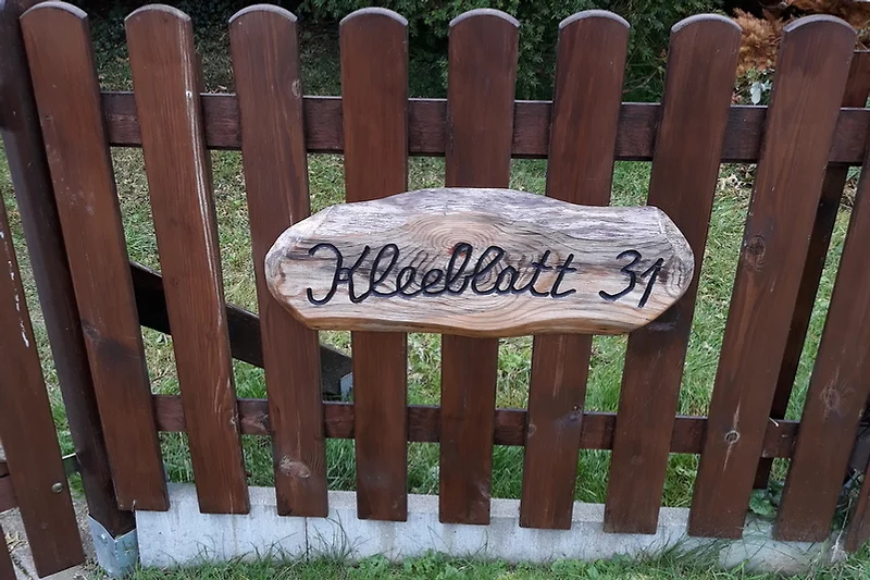Holzzaun mit Namensschild und gepflegtem Holzfinish.