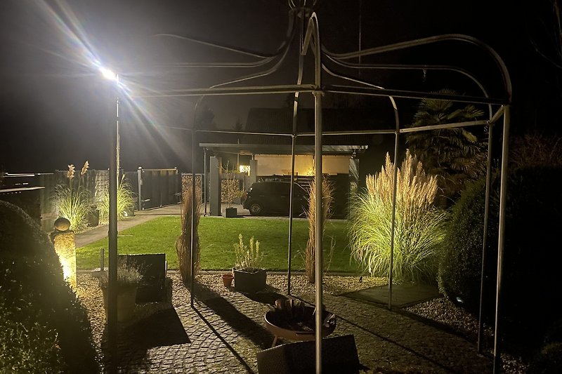 Beleuchteter Gartenweg mit Mitternachtsbeleuchtung und Landschaftsgestaltung.