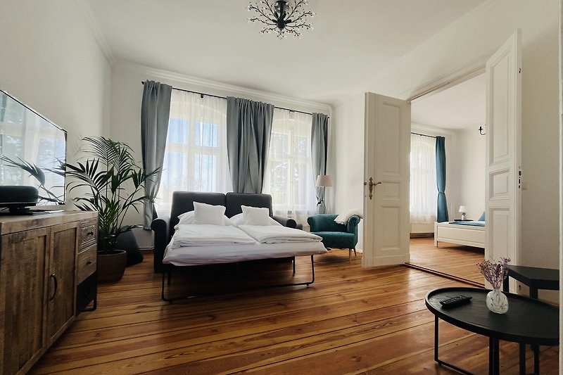 Einladendes Wohn- und Schlafzimmer mit elegantem Holzfußboden.