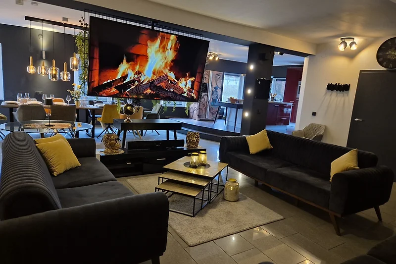 Wohnzimmer mit Sofa, Couchtisch, TV und stilvoller Beleuchtung.