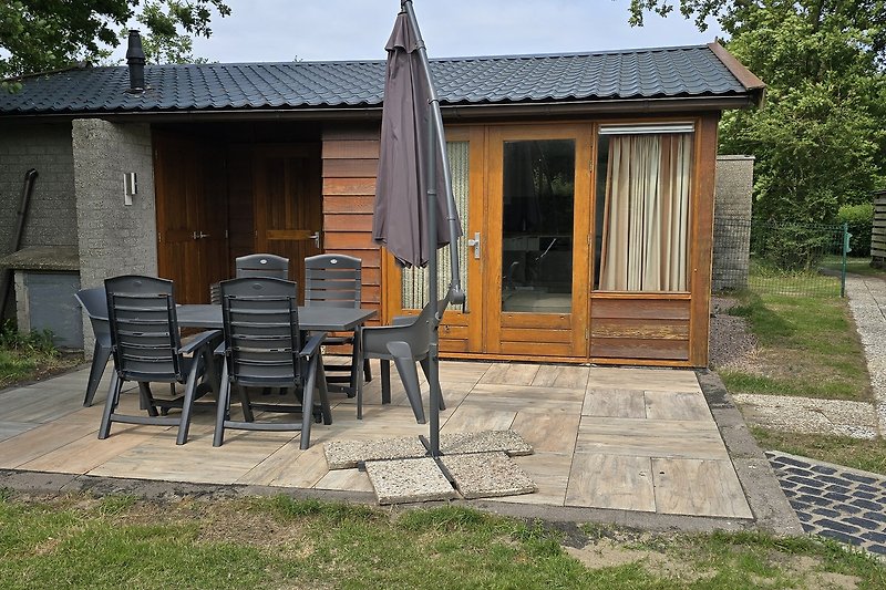 Holzhaus mit Garten, Terrasse und Schuppen im grünen Hinterhof.
