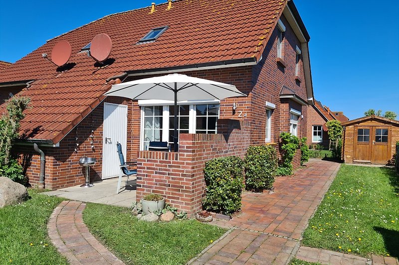 Ziegelhaus mit gepflegtem Garten und einladender Einfahrt.