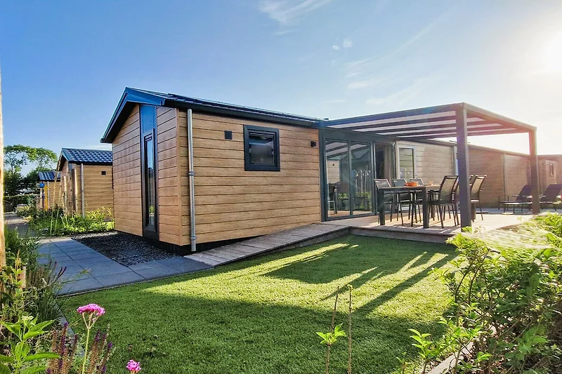 Garten nach Süden mit Holzterrasse und beleuchtetem Pavillon, Teakholz-Esstisch für 6 Personen.