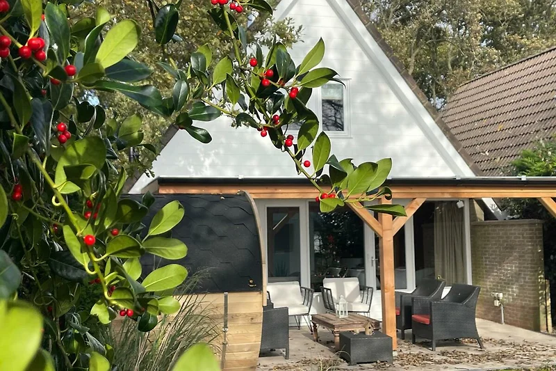 Gemütliches Ferienhaus mit blühendem Garten und schattiger Terrasse.