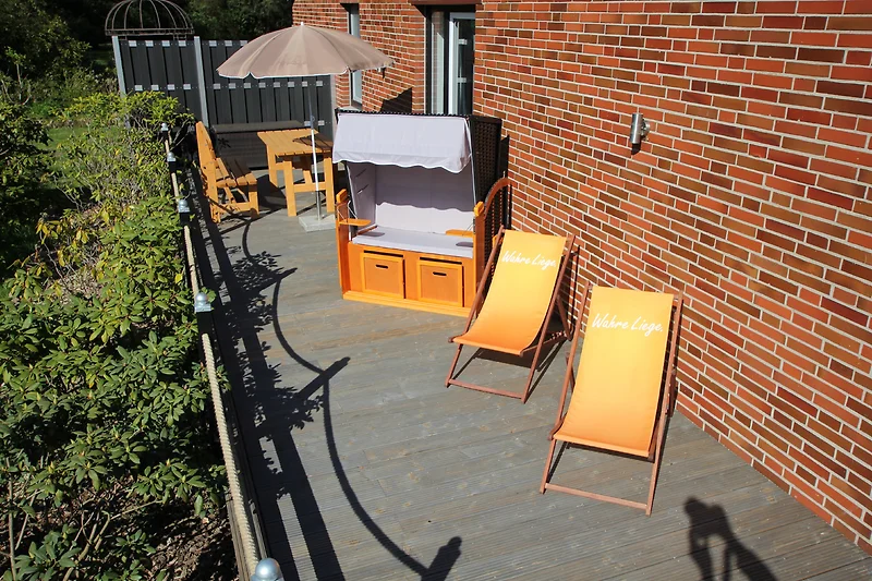 Großzügige Terrasse mit Holzdeck, Outdoor-Möbeln und Blumentöpfen.