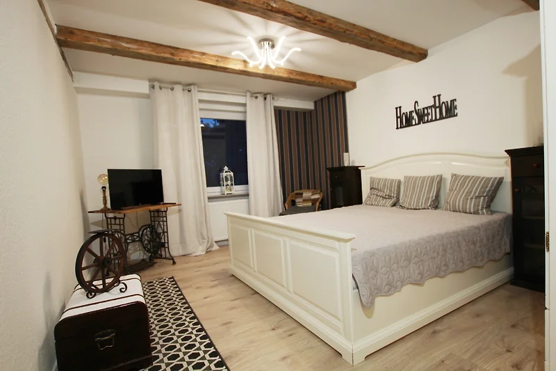 Gemütliches Schlafzimmer mit eleganter Beleuchtung und Holzmöbeln.