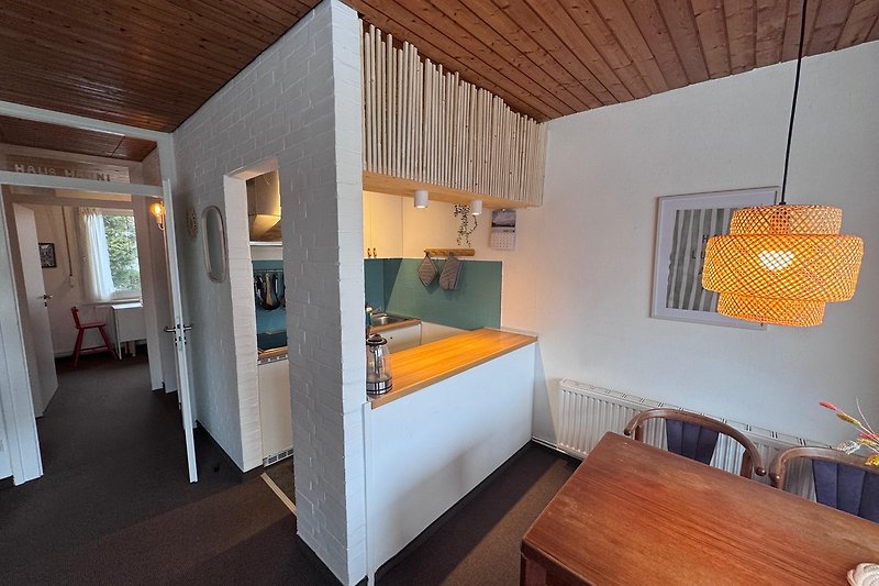 Moderne Küchenzeile mit Theke und Blick in den Essbereich und Garten