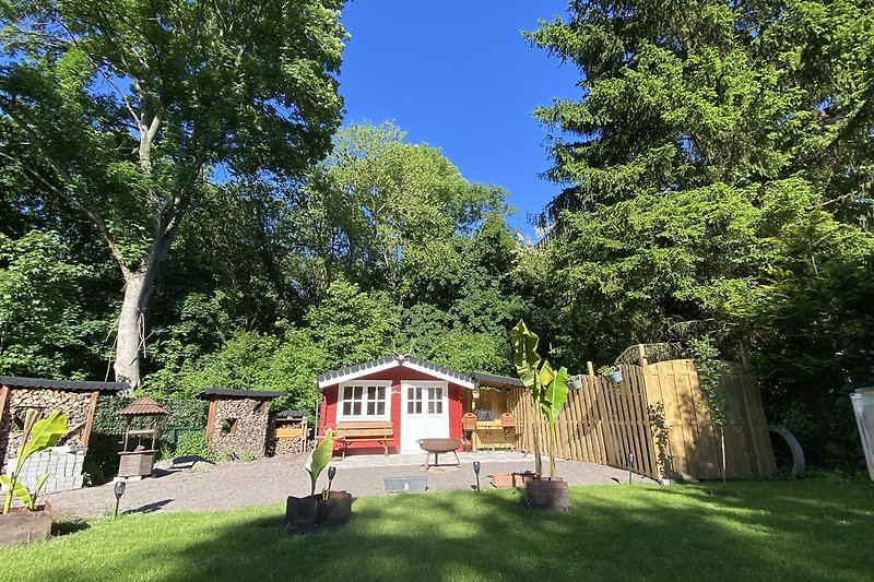 Garten mit Blockhütte und gepflegter Landschaft.