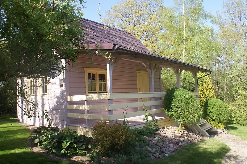 Gemütliches Ferienhaus mit Garten und Veranda, umgeben von Natur.