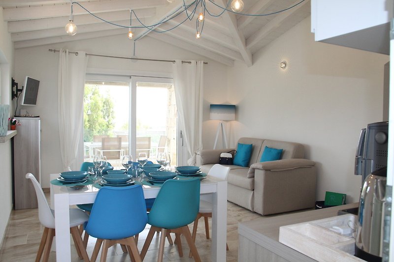 Gemütliches Wohnzimmer mit Couch, Kaffeetisch und Zimmerpflanze.