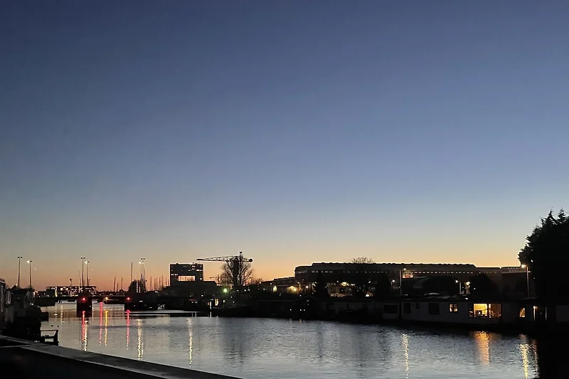 Boven met uitzicht vanuit het raam oer het water en de stad aan de overkant.