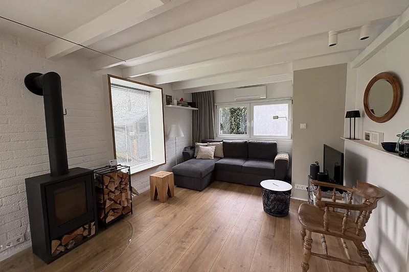 Großzügiger Wohnbereich mit Kamin, Sofa, TV und eleganter Beleuchtung.
