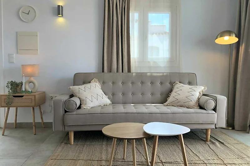 Gemütliches Wohnzimmer mit Couch, Kissen und stilvoller Beleuchtung.