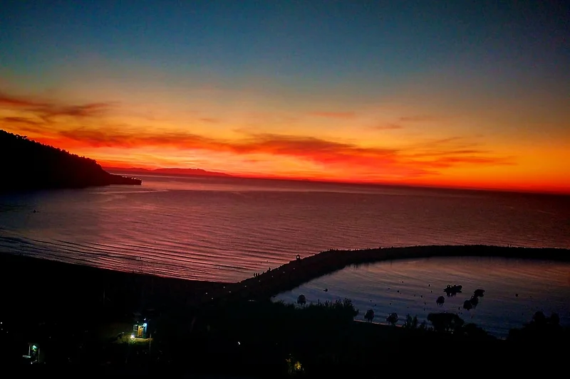 Sonnenuntergang am Meer mit weitem Horizont und goldener Spiegelung.