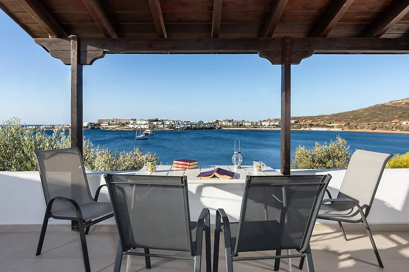 Balkon mit Meerblick, Tisch und Pflanzen.