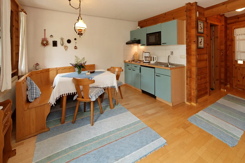 Gemütliches Wohnzimmer mit Holzmöbeln und großen Fenstern.