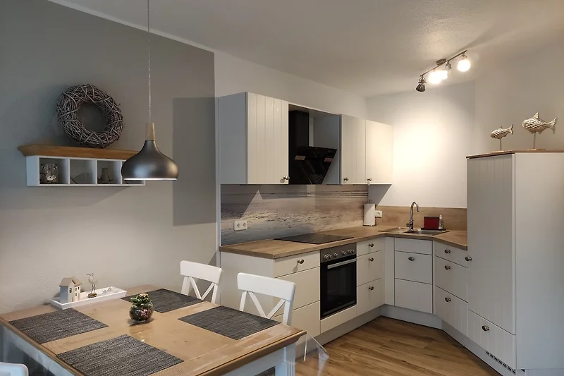 Moderne Küche mit Holzschränken, Gasherd und Edelstahlgeräten.