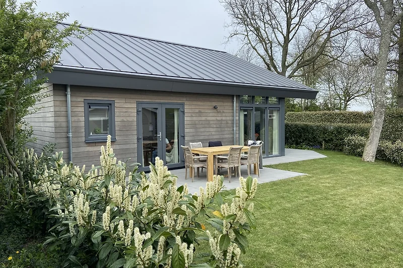 Großes Grundstück mit Haus, gepflegtem Rasen, Nebengebäude und Zufahrt.