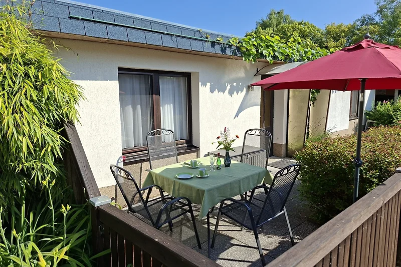Garten mit Sitzgruppe unter schattigen Bäumen