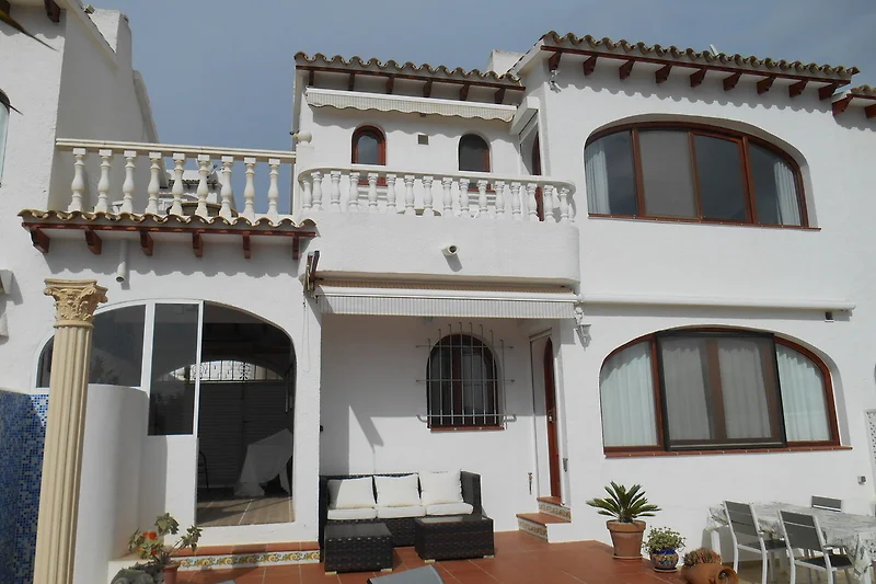 Villa mit Balkon und Palmen in ruhiger Wohngegend.