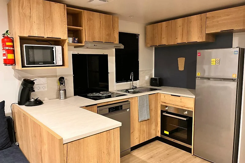 Voll ausgestattete Küche mit Holzfronten, Geräten und großzügiger Arbeitsfläche.