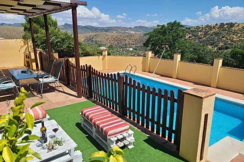 Entspannen Sie am Pool mit schattiger Terrasse und Holzmöbeln.