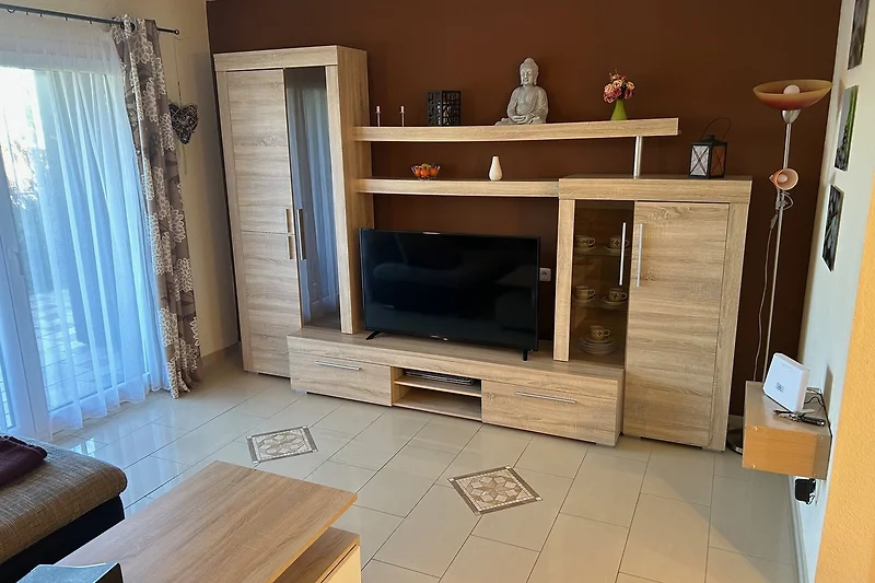 Gemütliches Wohnzimmer mit gefliestem Boden und moderner Unterhaltung.