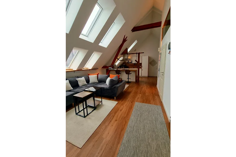 Helles Wohnzimmer mit Holzdetails, klaren Formen und gepflegtem Mobiliar.