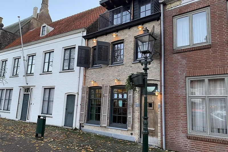 Historisches Almosenhaus mit Sprossenfenstern und markantem Schornstein.