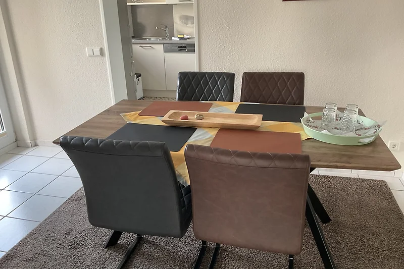 Esszimmer mit modernen Stühlen und Tisch aus edlem Naturmaterial.