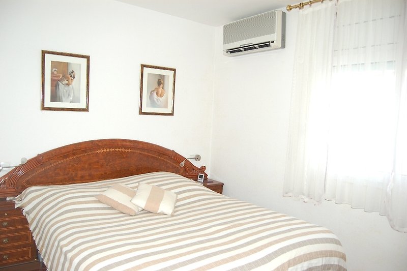 Schlafzimmer mit Doppelbett  (2 Einzelmatratzen), Klima, Fliegengitter, Kleiderschrank und Spiegelkommode.