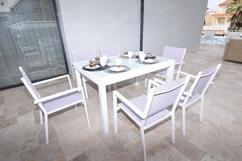 Riesiger Terrassenbereich mit : Sonnenliegen, Esstisch mit Stühlen, Lounge und Holzkohlegrill.  Zugang zum Kanal und kle