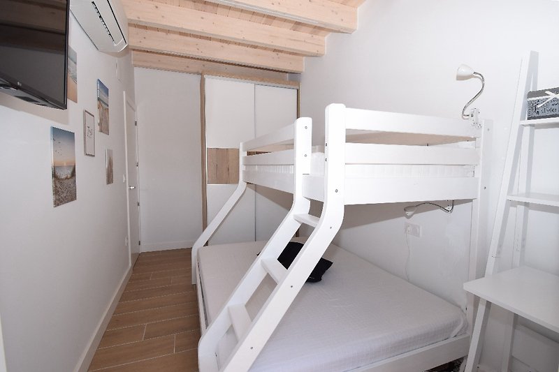 Schlafzimmer mit Doppelbett, Klima, Einbauschrank, SAT-TV und Fenster zur hinteren Terrasse (mit Fliegengitter u. elektr