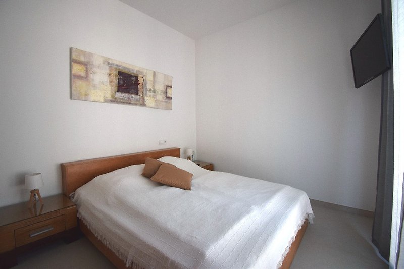 1 Schlafzimmer mit Doppelbett, SAT-TV, Kleiderschrank und Zugang zum vorderen Terrassenbereich