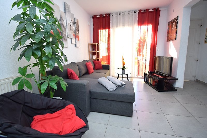 Gemütliches Wohnzimmer mit bequemer Couch, Pflanzen und stilvollem Interieur.