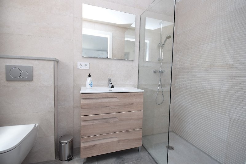 Badezimmer- Studio mit ebenerdiger Dusche, WC, Waschbecken, Fenster.